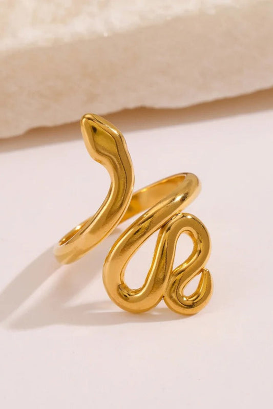 Bague Serpentine dorée photographiée de biais – forme fluide et brillante.