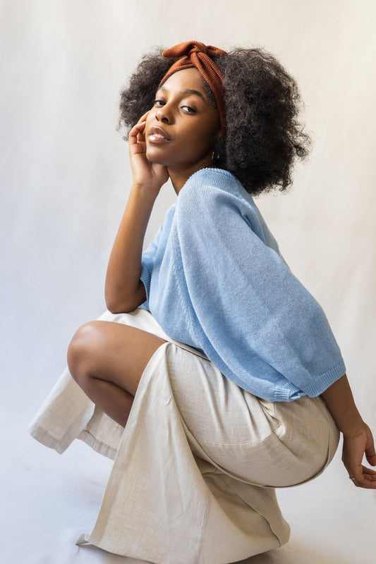 Bandeau torsadé brique porté sur cheveux bouclés, accessoire en tissu revalorisé