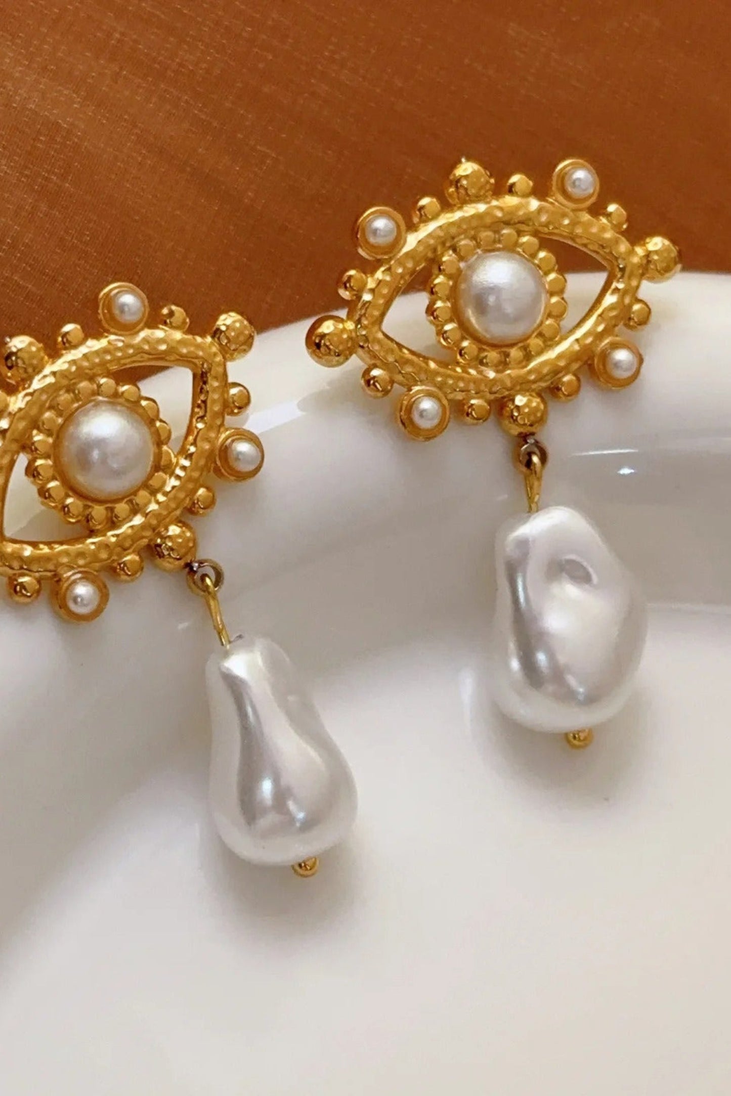 Boucles d’oreilles Œil Perlé dorées en acier inoxydable plaqué or avec perles nacrées pendantes.