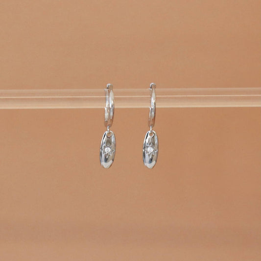 Vue de face des boucles d’oreilles Elavya – anneaux en argent et médaillon étoilé