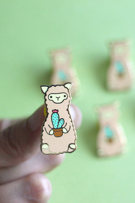 Épinglette cactus alpaga tenue entre les doigts – accessoire mignon