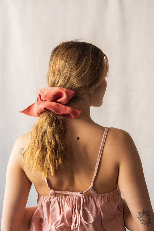 Détail du chouchou carré en lin rouille dans une queue basse