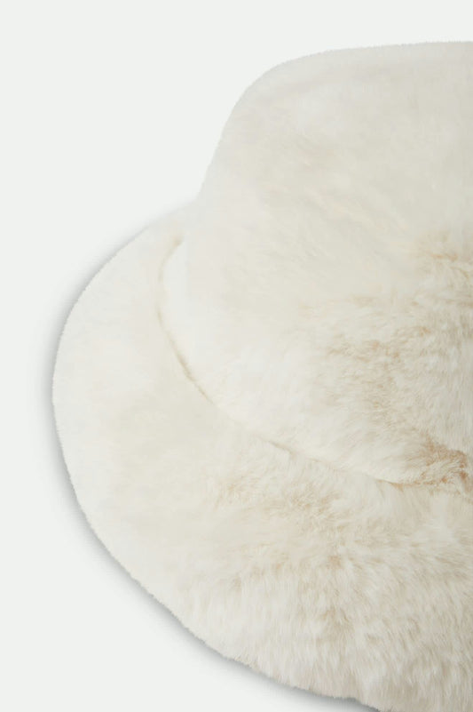 Gros plan sur la texture en fausse fourrure ultra-douce du bob blanc