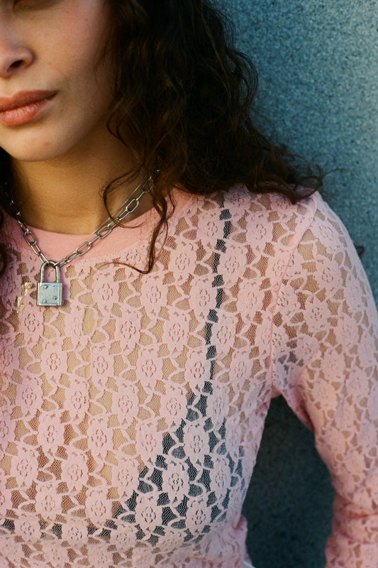 Vue rapprochée du haut Dolly en dentelle rose – détail floral et encolure ronde