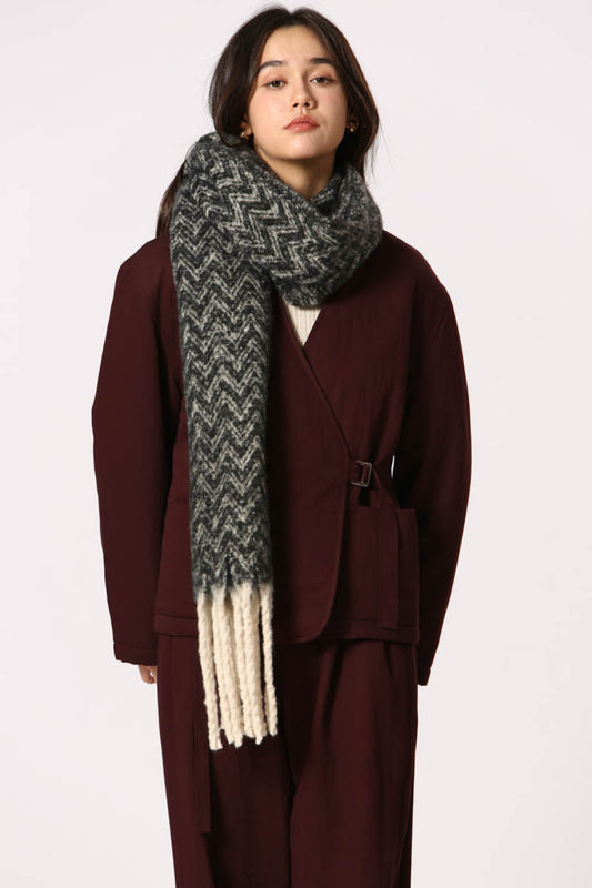Écharpe noire à motif chevron avec franges blanches, portée sur ensemble bordeaux