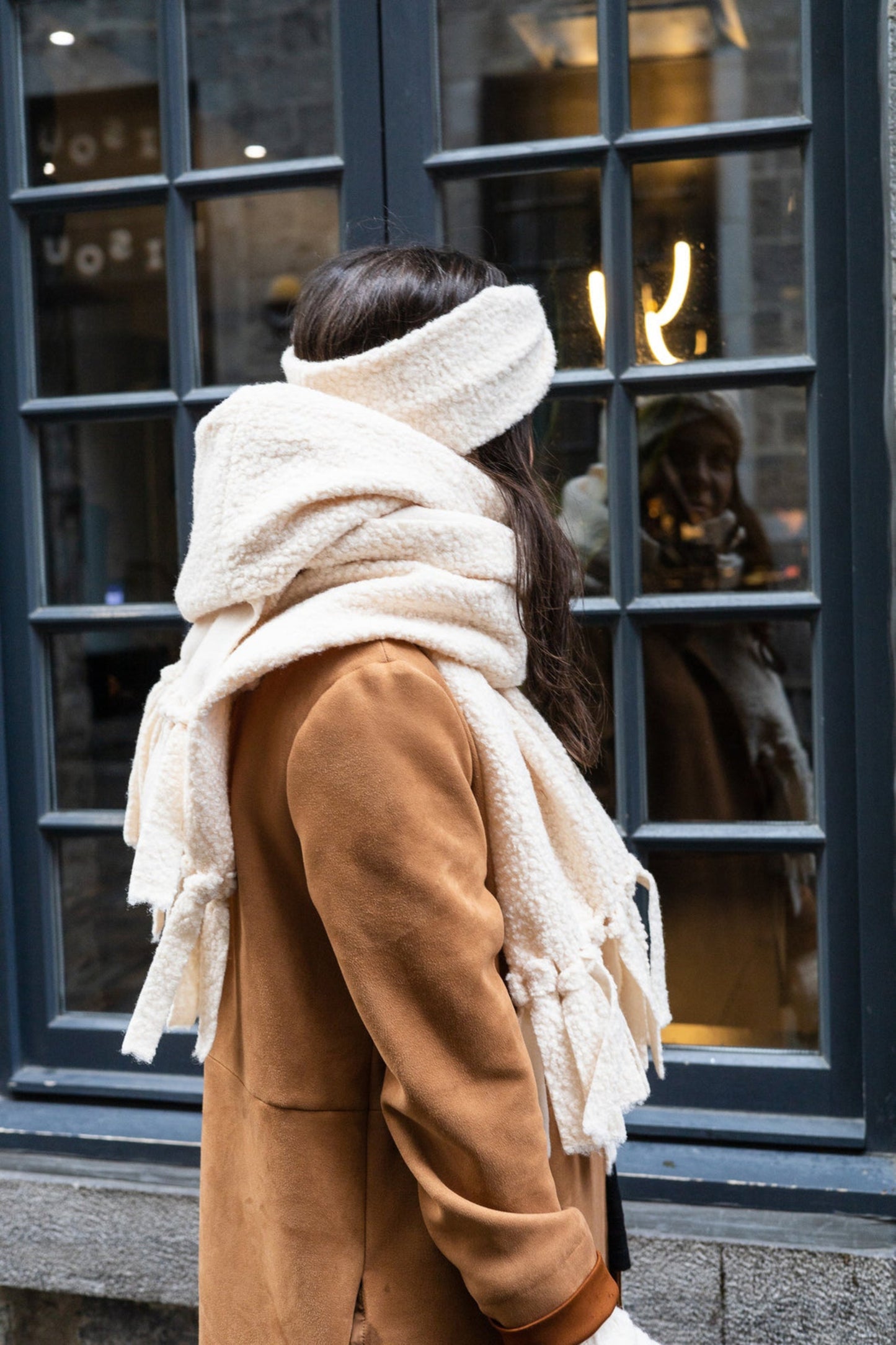 Écharpe crème volumineuse portée autour du cou, look cocooning