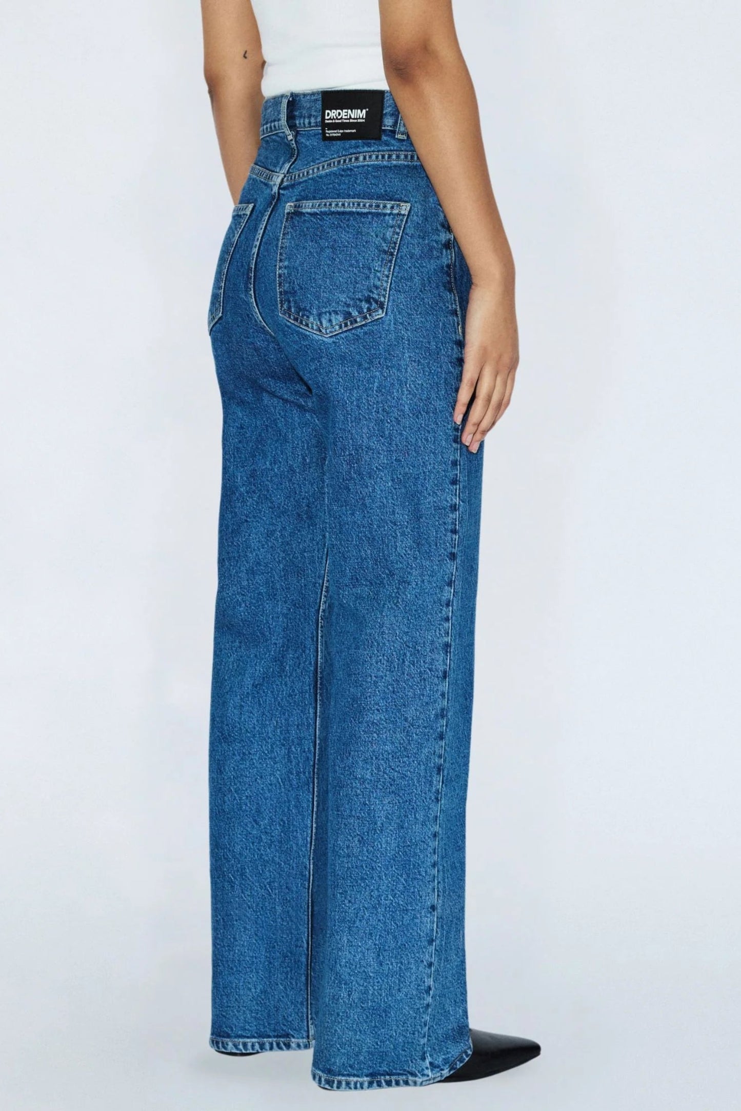 Vue de côté dos du jeans Echo bleu denim rétro avec jambe droite, taille haute et coupe structurée.