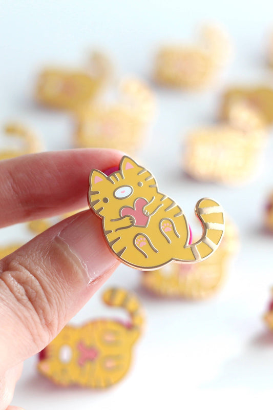 Épingle Chat Câlin tenue en main – chat jaune rayé avec cœur rose