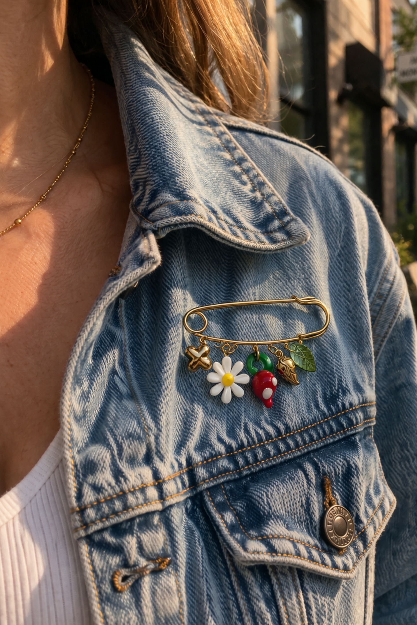 epinglette doree avec charms fleur blanche piment rouge et feuilles portee sur veste en jean + bijou original et colore
