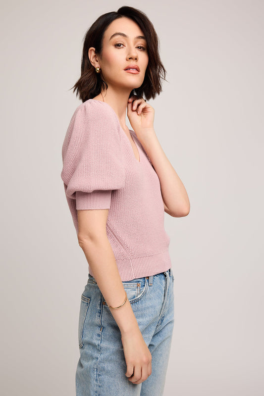 Vue de profil montrant le volume des manches bouffantes et la coupe féminine du haut