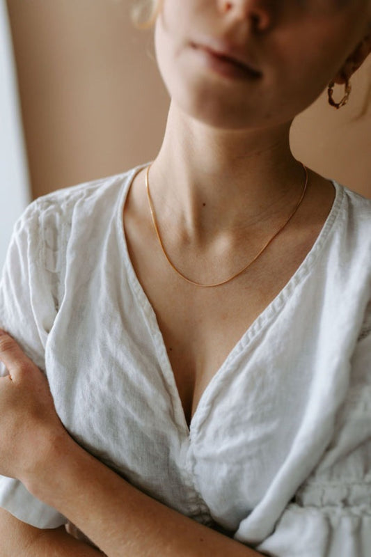 Chaîne dorée fine portée autour du cou – bijou minimaliste élégant