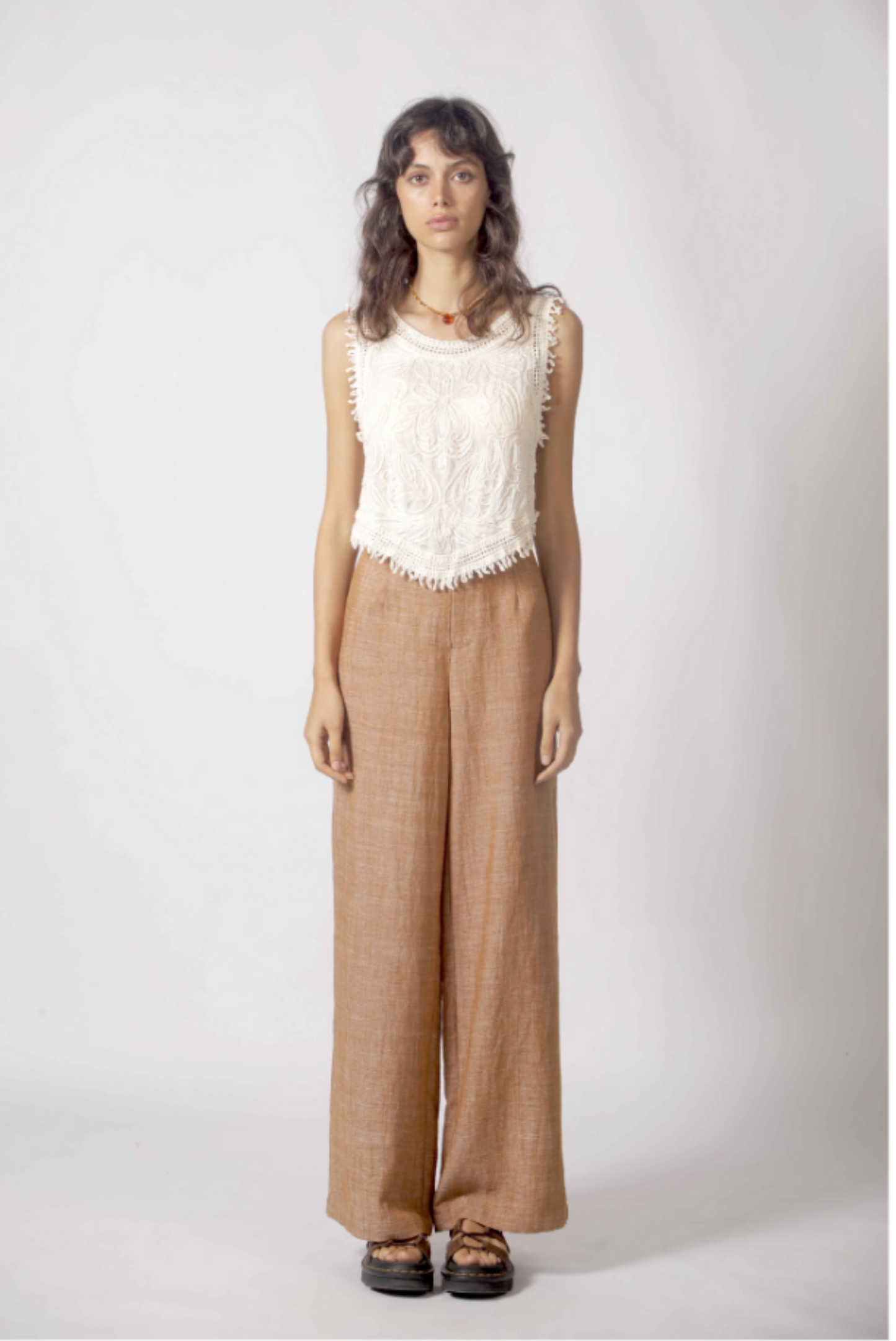 Débardeur blanc brodé bohème porté avec pantalon fluide beige