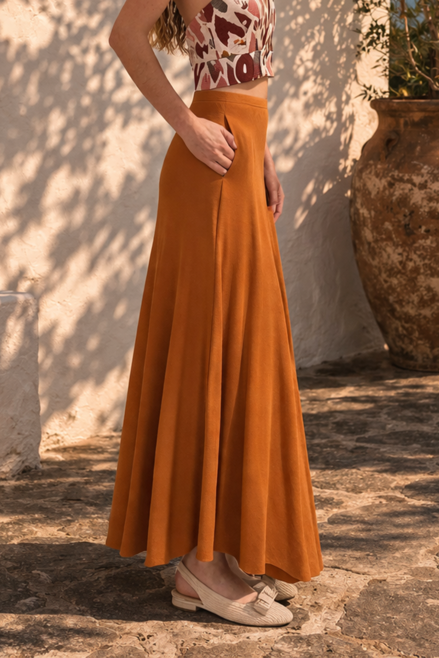 Jupe longue orange vue de profil avec coupe trapeze et mouvement fluide