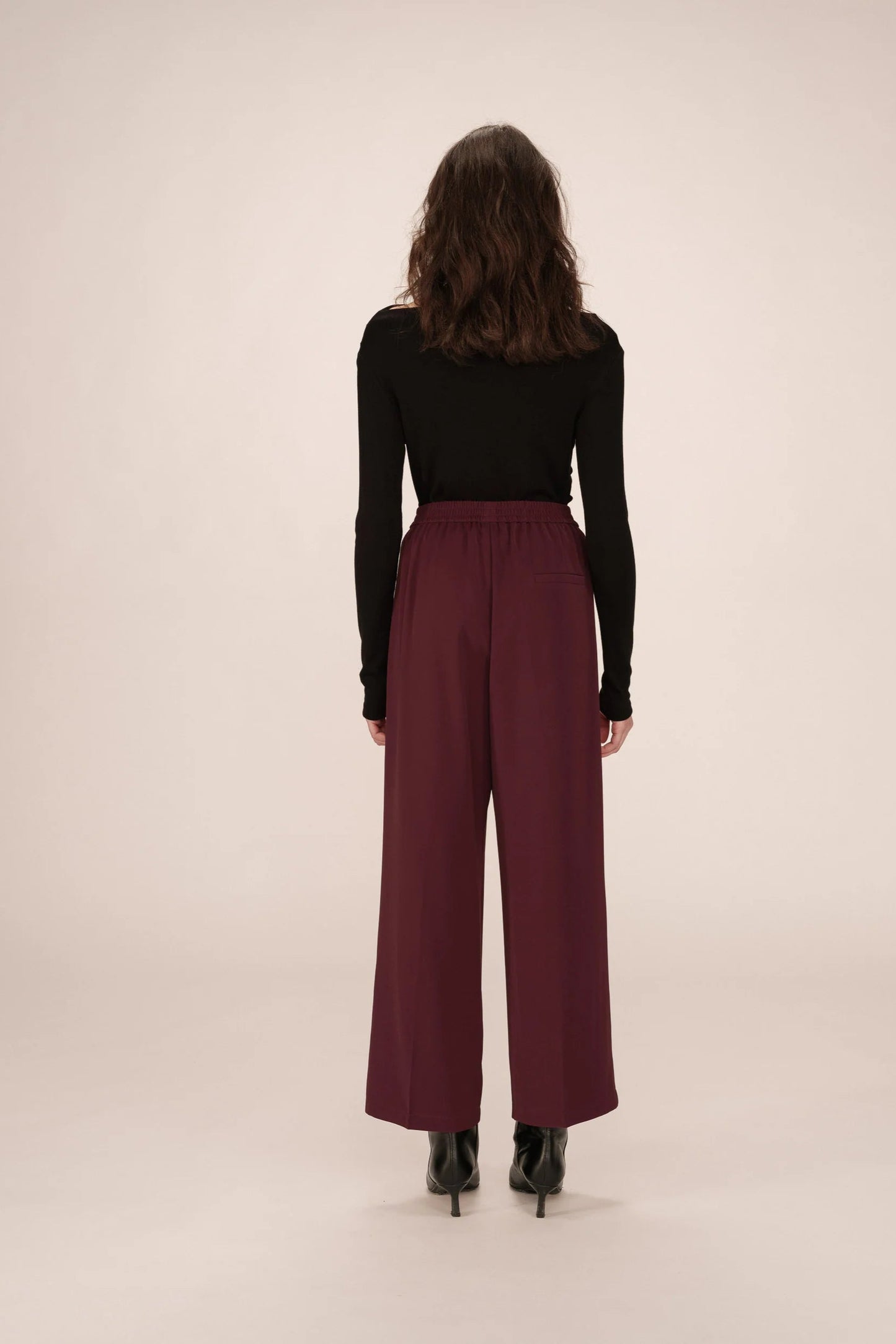 Vue entière de dos du pantalon Noblesse bordeaux porté avec un haut noir ajusté