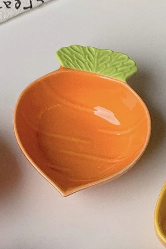 Petit plat en céramique orange en forme de carotte, avec feuille verte