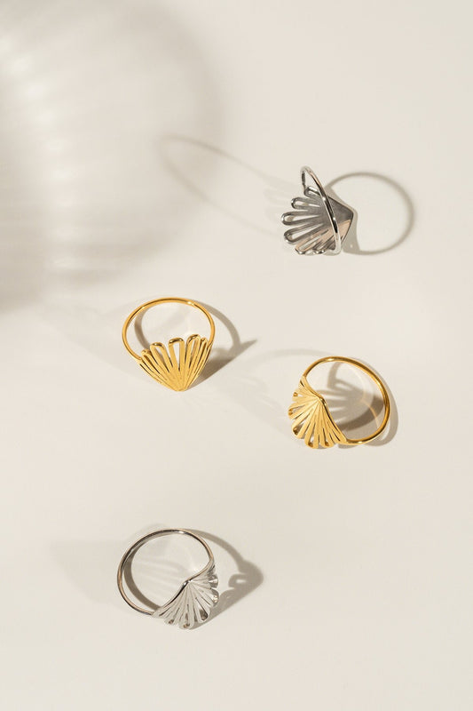 Sur cette photo, il y a deux bagues dorées et deux autres argent. Elles sont posées de différentes façons ce qui permet de voir que c'est une bague délicate.