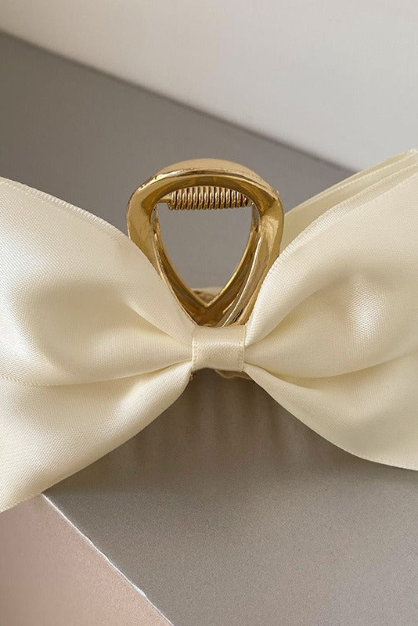 Pince à cheveux blanc cassé en satin avec boucle dorée et grand nœud élégant