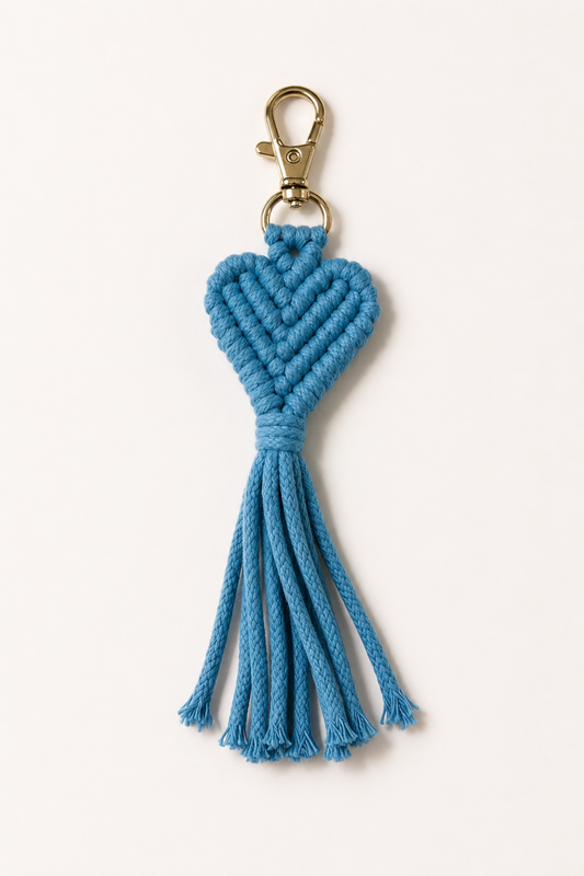 Porte-clé cœur en macramé bleu avec frange et attache dorée, idéal pour décorer un sac ou des clés.
