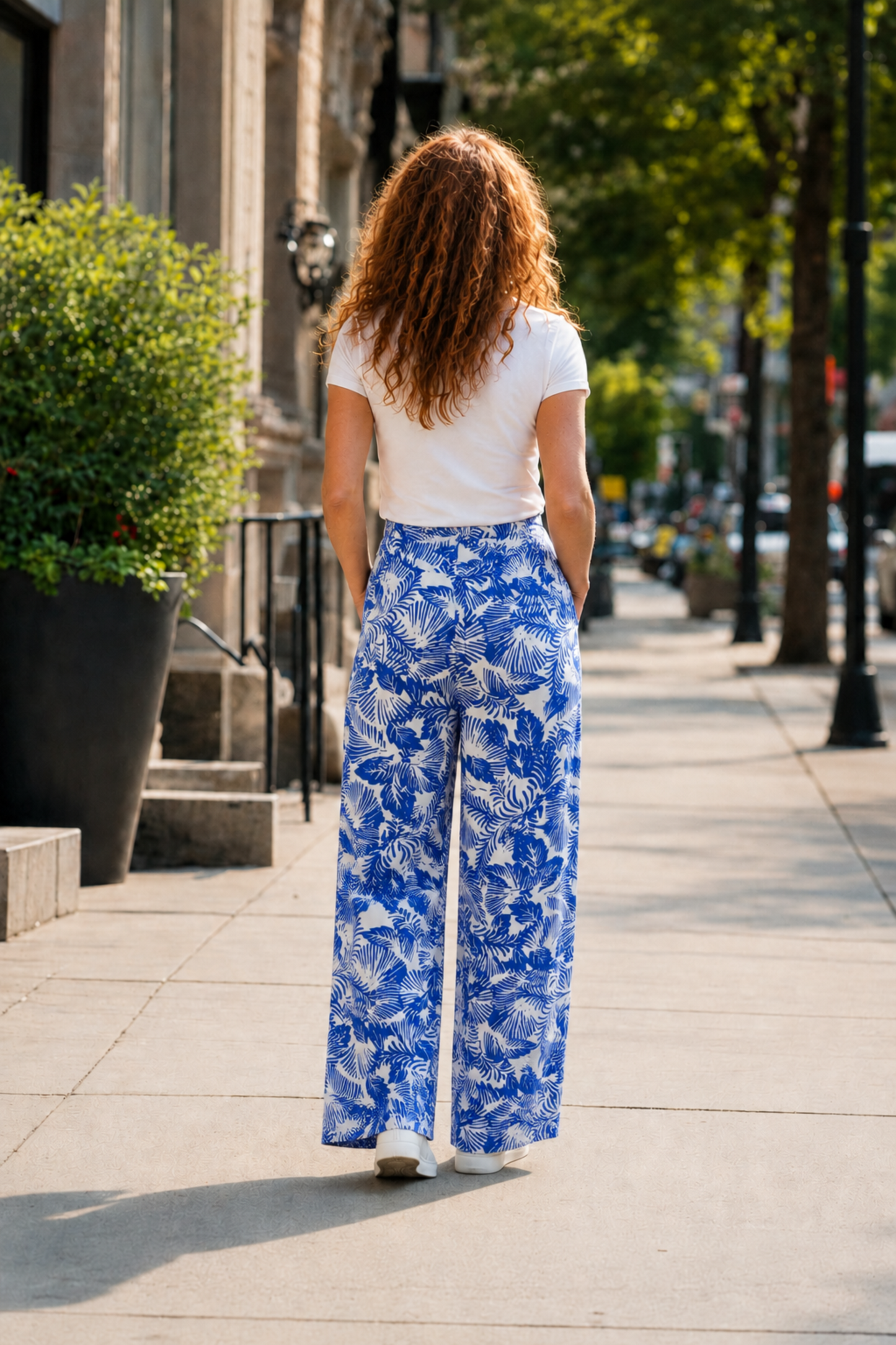 Pantalon évasé Prague bleu vu de dos avec taille haute, jambe large et imprimé tropical contrasté.