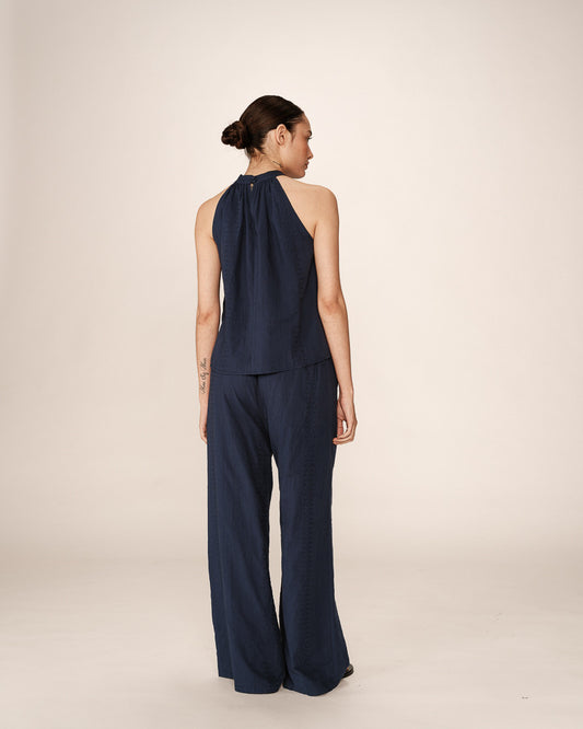 Top bleu marine porté de dos avec détail de col boutonné