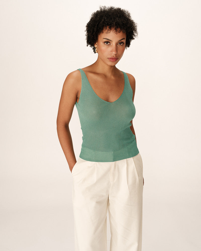 Top vert scintillant porté avec pantalon blanc