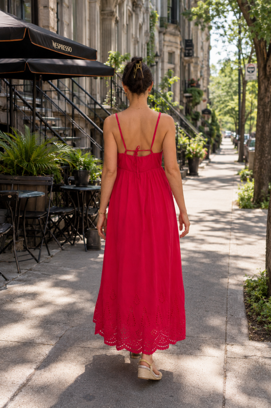 Robe longue fuchsia en coton portée de dos avec dos ouvert à nouer et finition brodée.