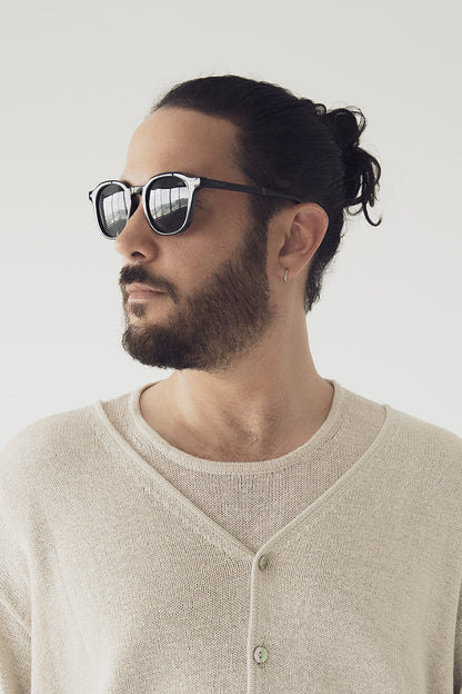 Homme de profil avec les lunettes Nika noir. Monture pliable noire et design épuré.