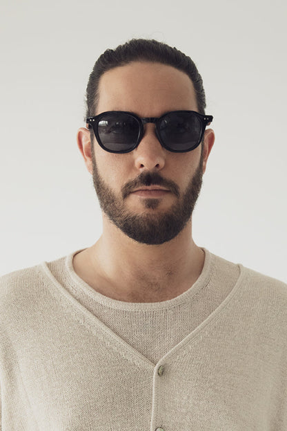 Homme portant les lunettes Nika noir face à la caméra. Monture noire classique avec verres polarisés.