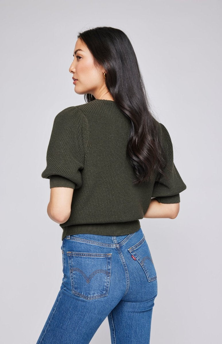 Pull col V à manches bouffantes en tricot trés doux de couleur vert olive. Manches 3/4, resserré aux coude et la taille porté avec un jeans bleu.. Vu de dos