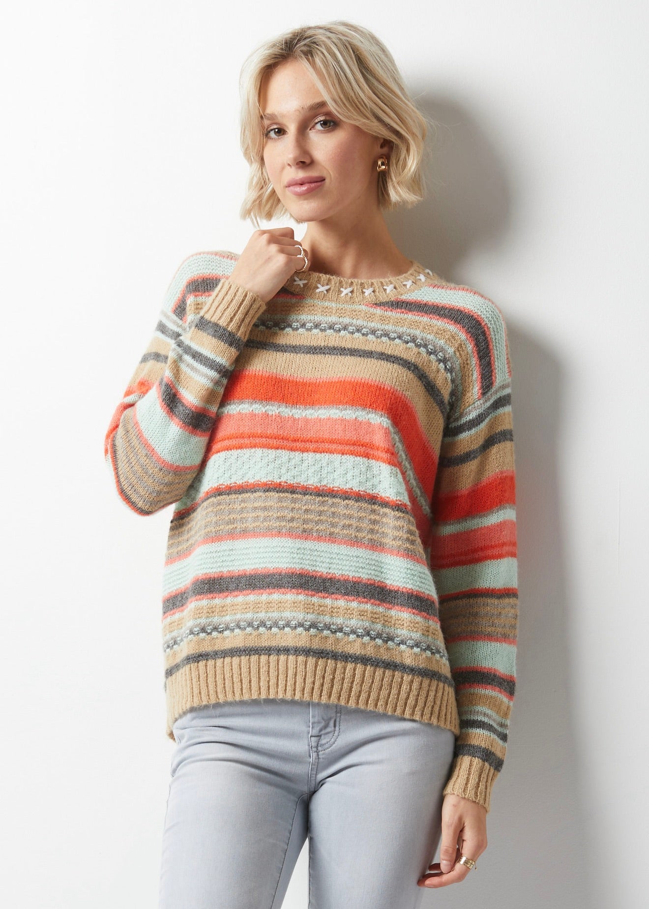 Image d'un pull en laine texturé et coloré avec des motifs lignés et des détails de points de croix au col