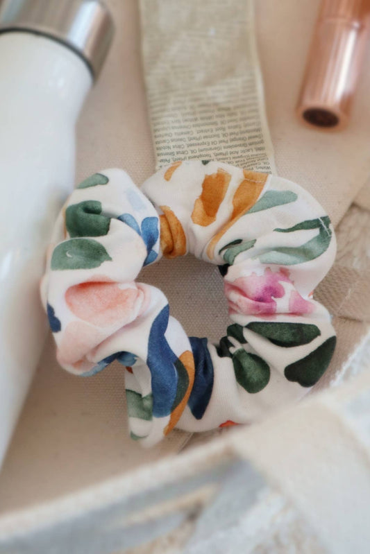 Chouchou Sierra Florals multicolore posé avec accessoires dans un sac