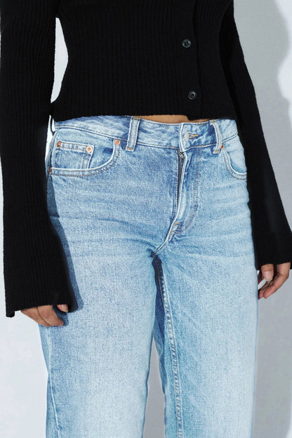 Détail devant du jeans Addy bleu denim clair avec bouton, braguette zippée, poches et passants.