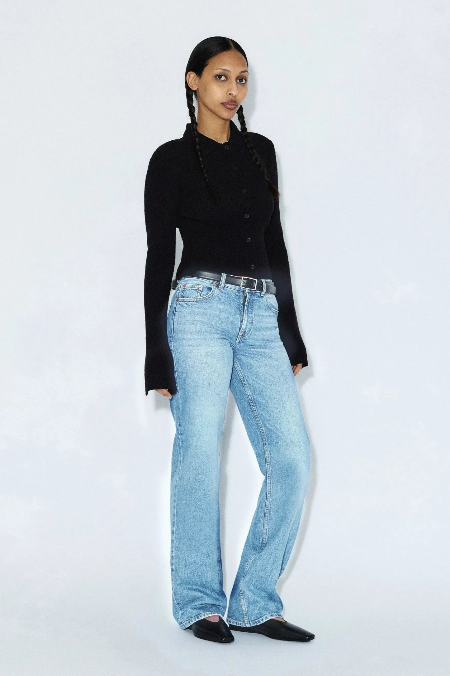 Jeans Addy bleu denim clair effet vintage porté avec une coupe taille haute et une jambe droite.