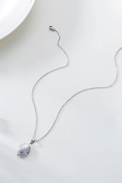 Collier medaillon ovale ouvrant en acier inoxydable finition argentee vue a plat