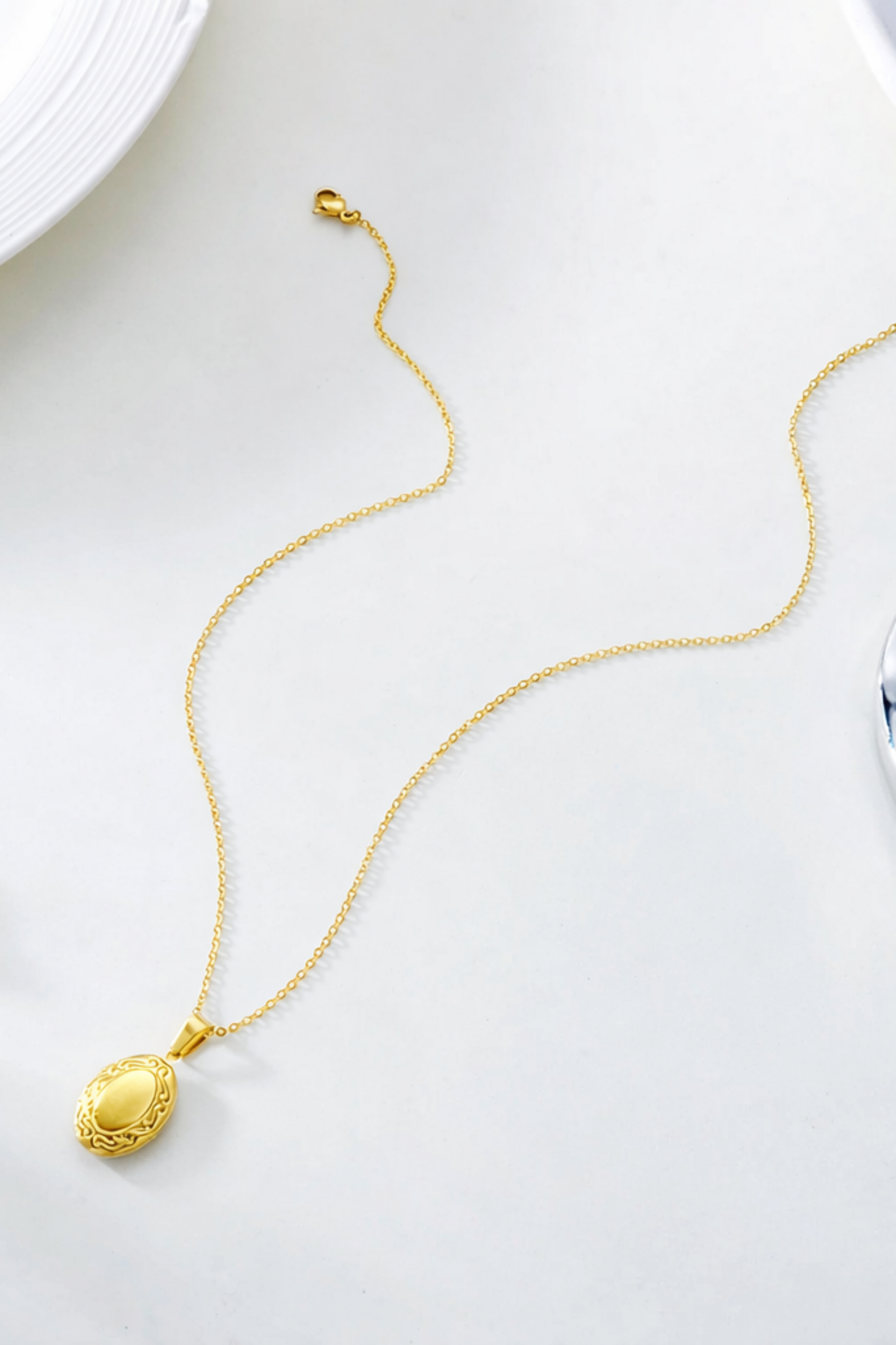 Collier medaillon ovale ouvrant en acier inoxydable plaque or finition doree vue a plat