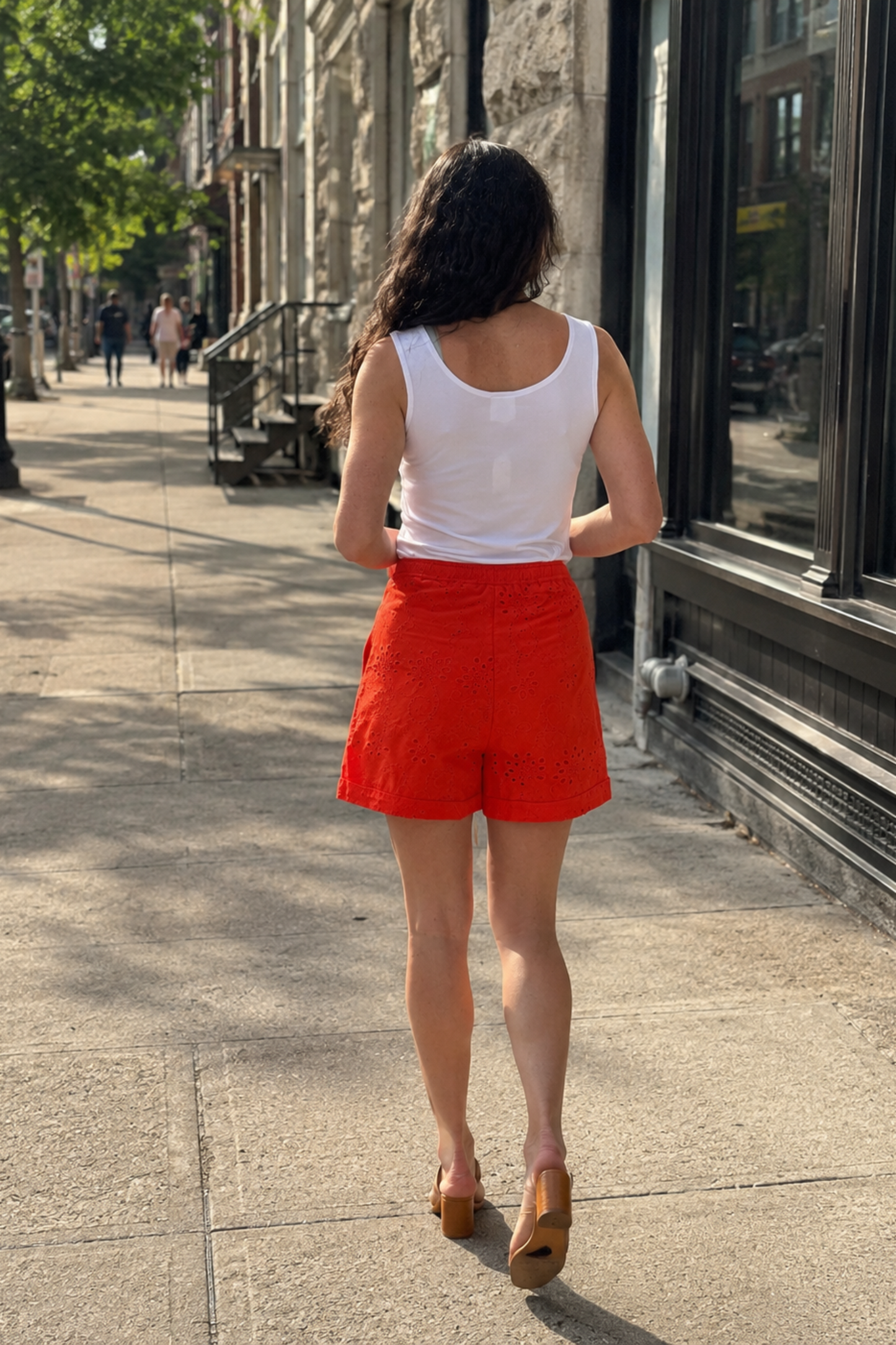 Vue de dos du short Asha orange en broderie anglaise, avec coupe courte, tissu ajouré et allure estivale.