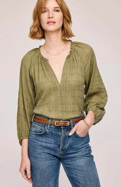 Femme portant le haut vert matcha avec col froncé et broderies – vue de face, manches longues
