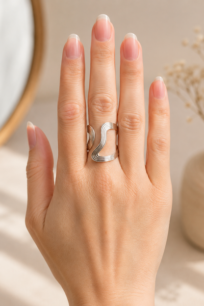 Bague Anna argent portée sur la main, avec forme ajustable et lignes sculpturales modernes.