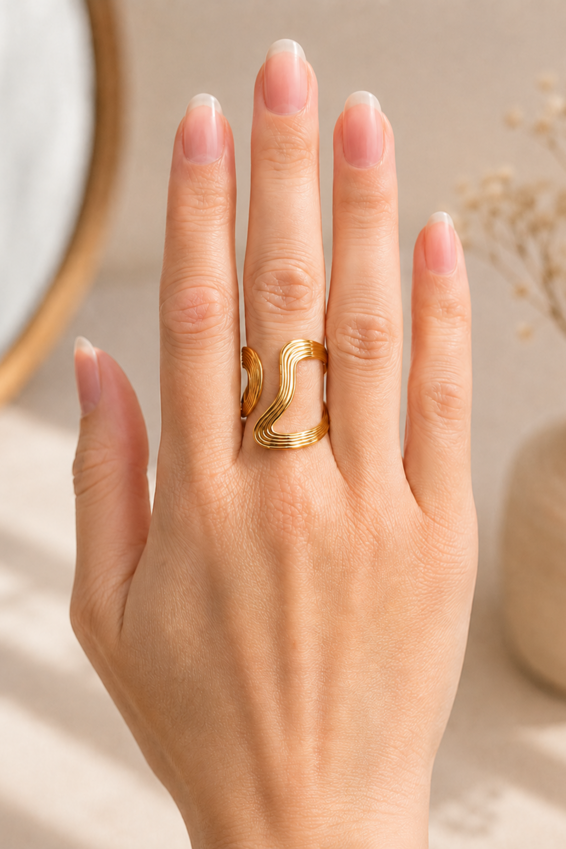 Bague Anna or portée sur la main, avec détails ondulés et style chic contemporain.