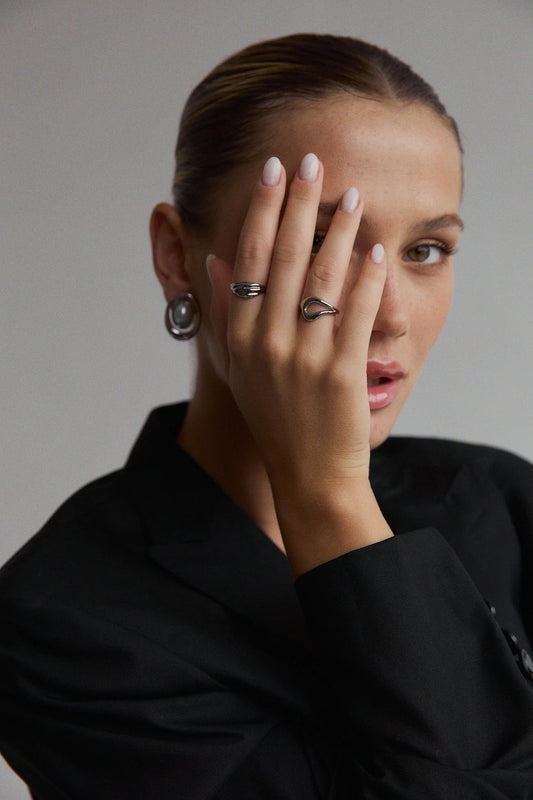 Gros plan sur la main avec la bague Gia en argent – anneau à forme courbe et moderne