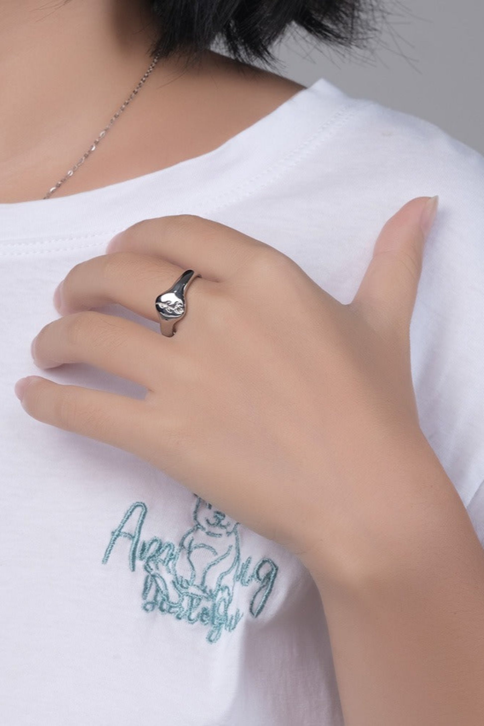 Bague chevalière fleur gravée portée sur la main – finition argentée au style chic et moderne