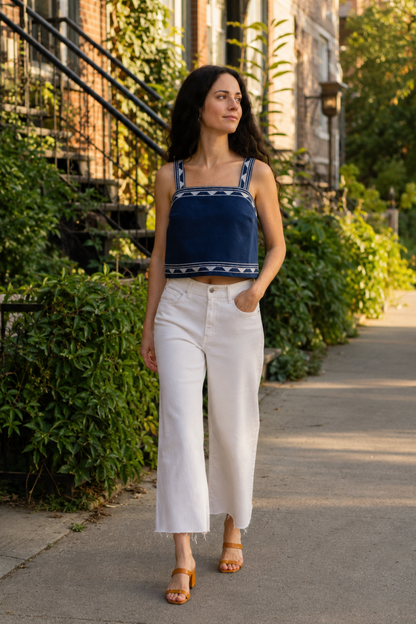 Débardeur bustier bleu marine porté avec un pantalon blanc dans une rue de Montréal, avec larges bretelles et style bohème chic.