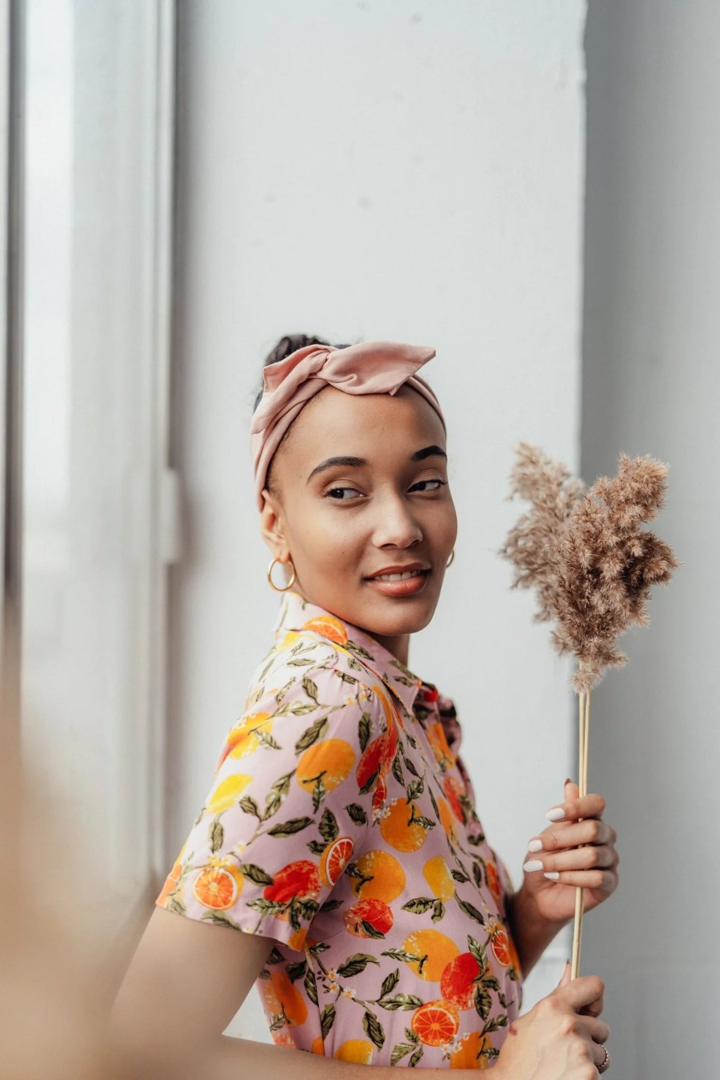 Détail du bandeau torsadé rose, noué sur le dessus de la tête