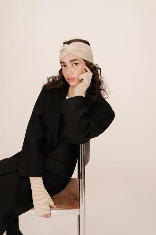 Bandeau Rona beige porté par un modèle assis, style chic et hivernal.