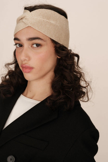 Portrait rapproché du bandeau Rona beige porté, mettant en valeur le noeud et la texture.
