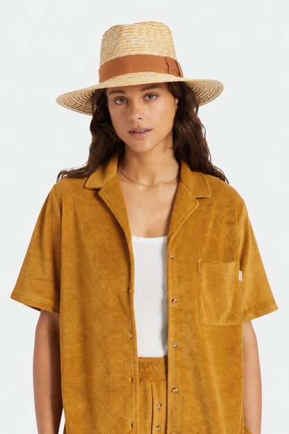 Femme portant le chapeau Barbara brun de face, avec paille de blé, bande brune et allure élégante tendance.