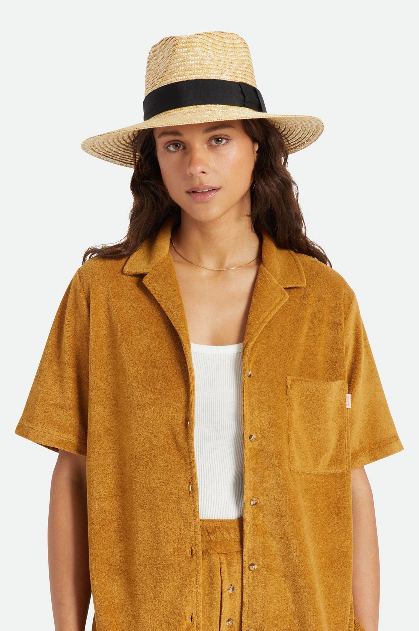 Femme portant le chapeau Barbara noir de face, avec paille de blé, bande noire et allure élégante tendance.