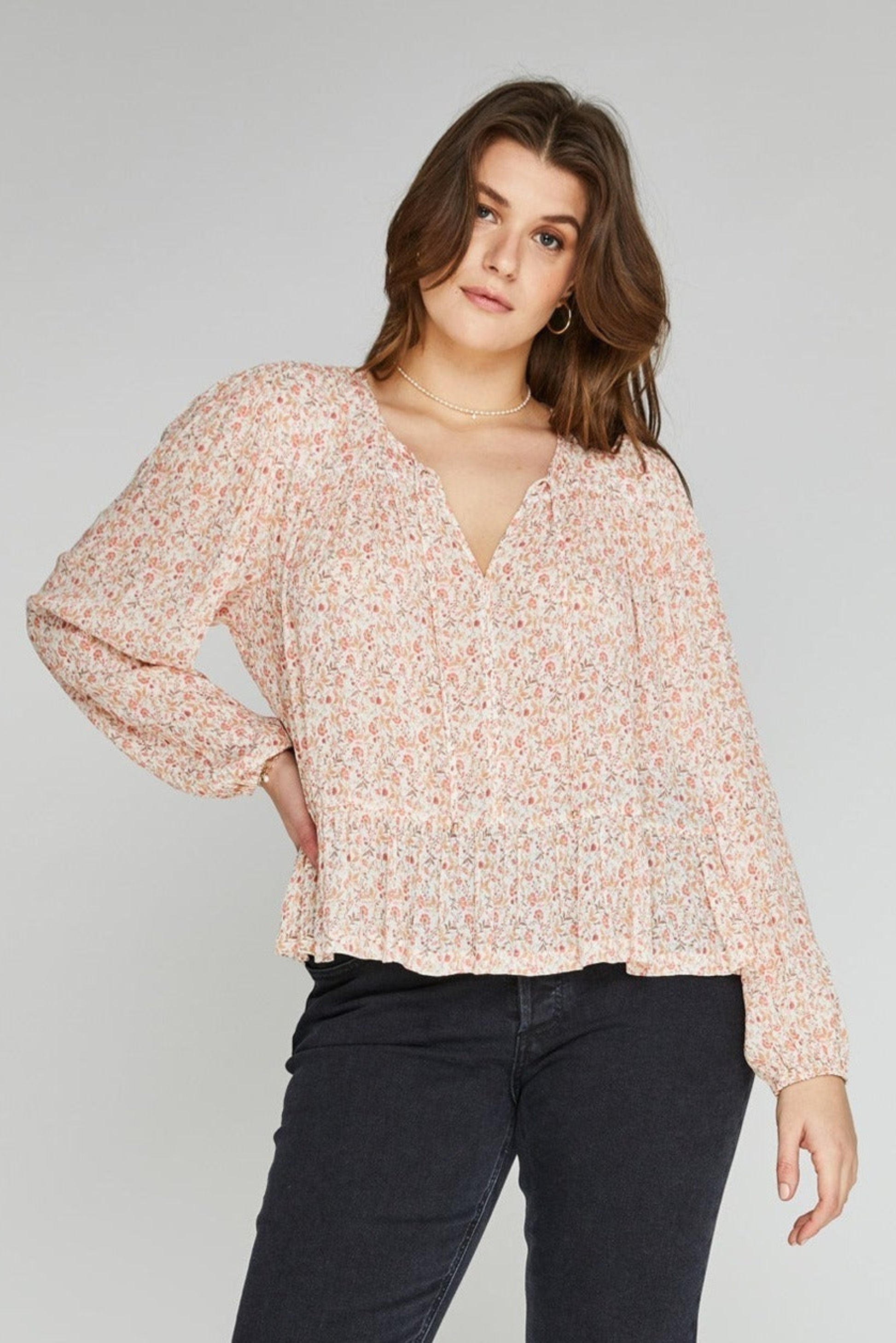 Blouse femme fluide avec imprimé fleuri délicat, liens à l’encolure et bas volanté.