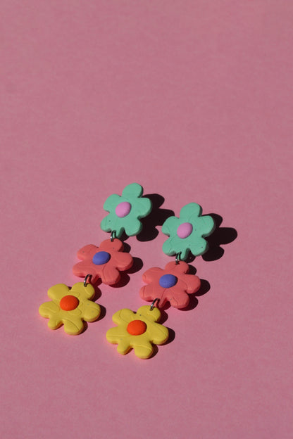 Boucles d’oreilles pendantes en forme de fleurs sur fond rose – fait main à Montréal

