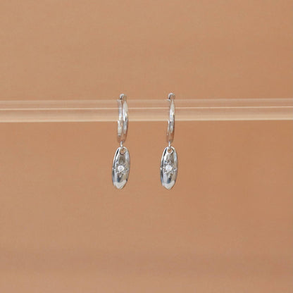 Vue de face des boucles d’oreilles Elavya – anneaux en argent et médaillon étoilé